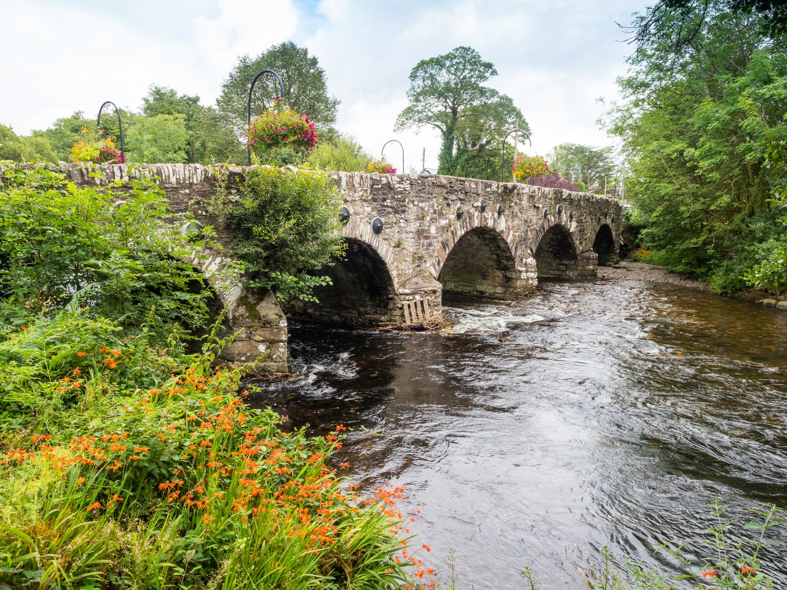 An old stone bridge with flower baskets on the Ring of Kerry