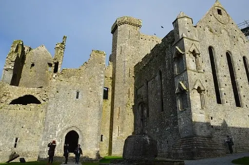 Stone medieval castle ruins with towers under blue sky