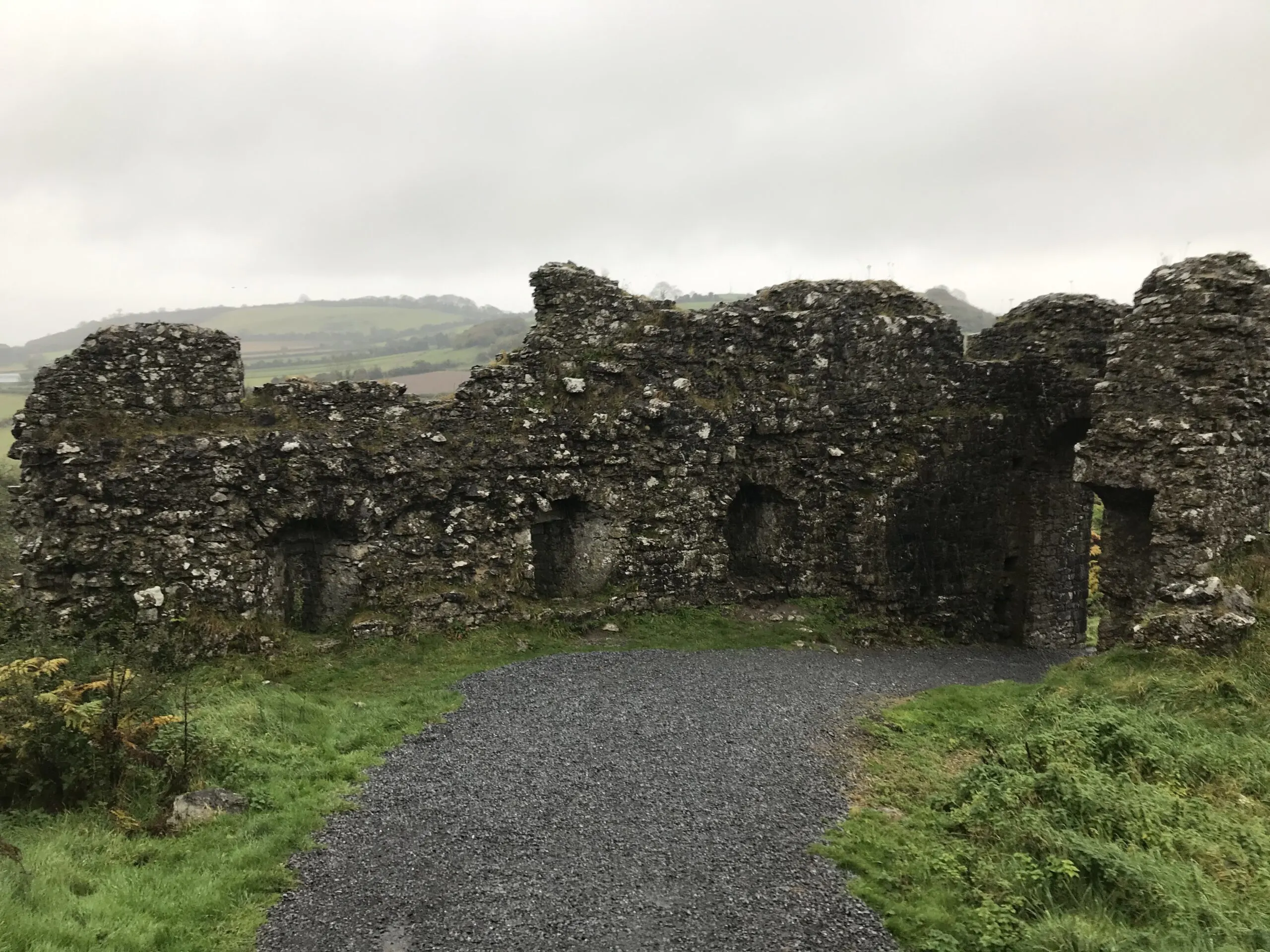 Stone ruins of an ancient Irish castle with cloudy sky