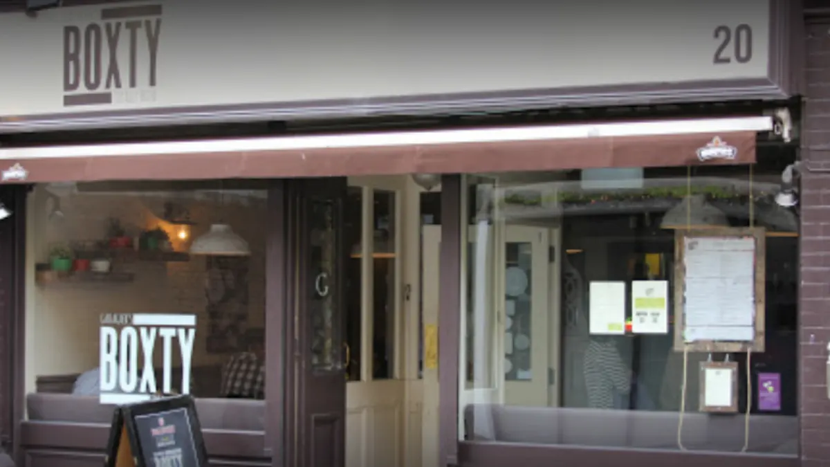 Storefront of Boxty restaurant with large window display and number 20 address