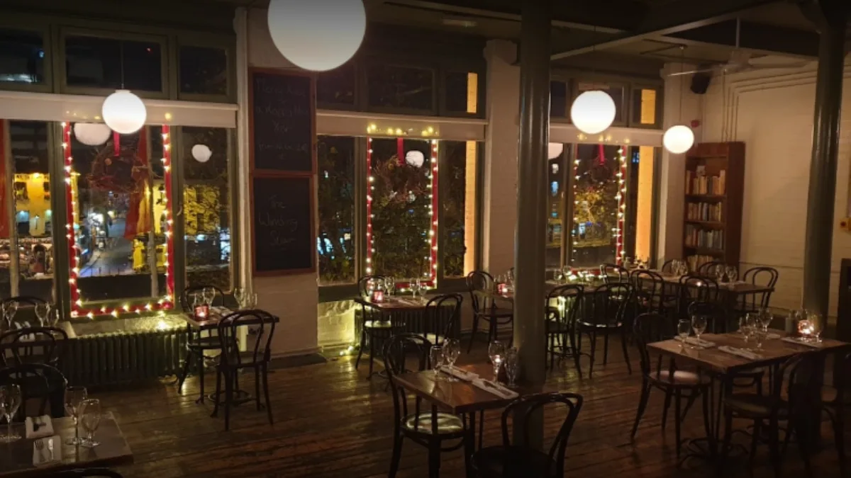 Festive restaurant interior with red and gold Christmas lights framing windows