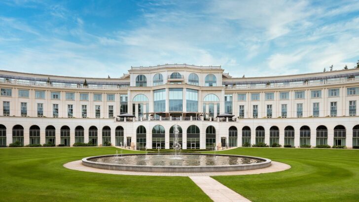 Elegant neoclassical courtyard with central circular fountain and manicured lawn