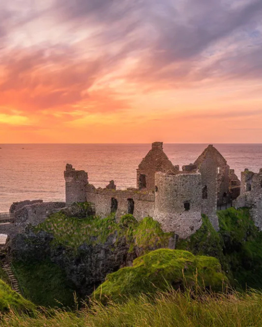 Sunset at ruins of Dunluce Castle located on the edge of cliff, Bushmills, Northern Ireland. Filming location of popular TV show Game of Thrones - Shutterstock