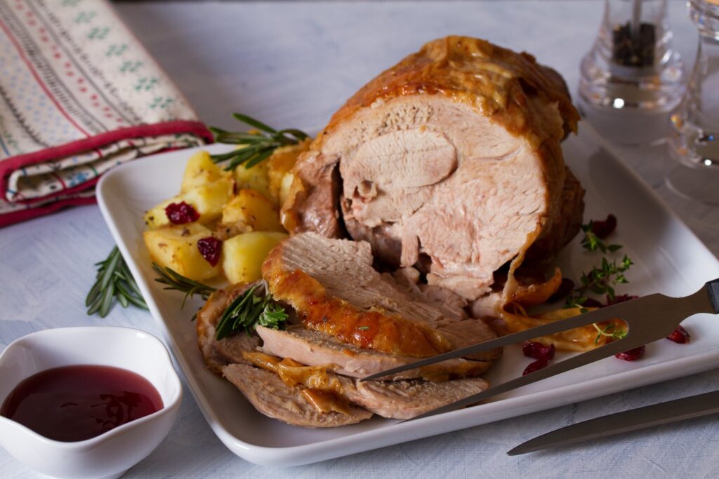 A roast turkey, carved, with roast potatoes