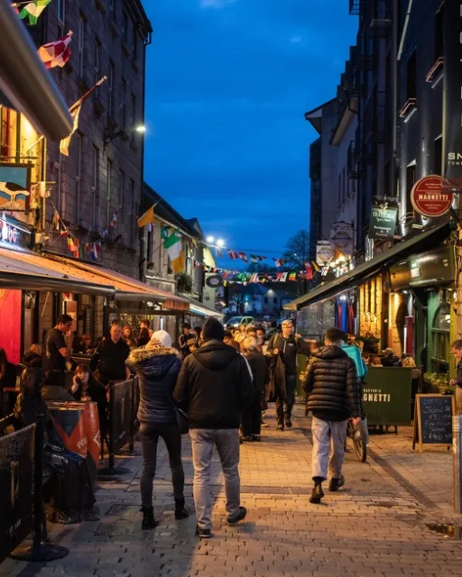 GALWAY, IRELAND - 5TH APRIL 23: The streets of Galway in Ireland during the evening along Quay Street, showing bars, people and nightlife.