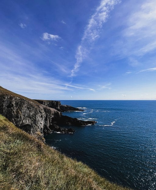 Scenic West Cork countryside in Ireland — rolling green hills meeting the Atlantic coast