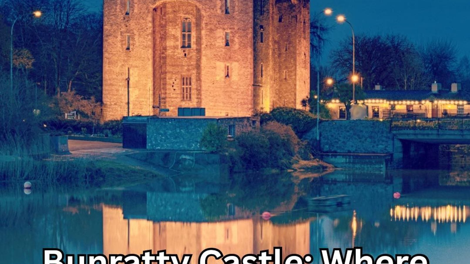 Bunratty Castle illuminated at twilight with its reflection in the River Ratty, County Clare, Ireland