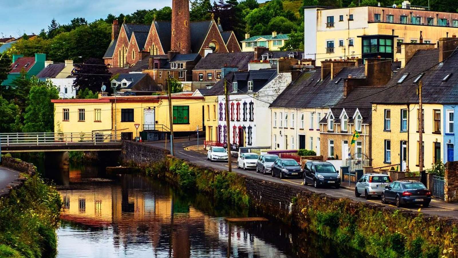 A grey, overcast bridge over a tranquil river in Donegal, Ireland, casting a somber mood over the ancient landscape