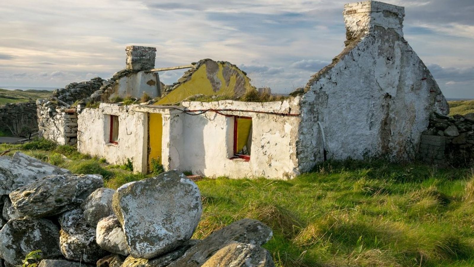 Old abandoned thatched cottage ruin in Donegal, Ireland, with stone walls open to the sky