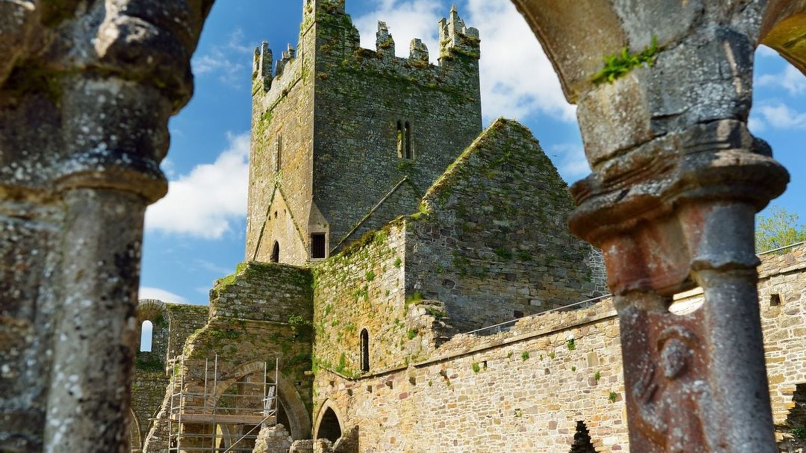Medieval ruins of an Irish monastic site with carved stone arches and ancient stonework