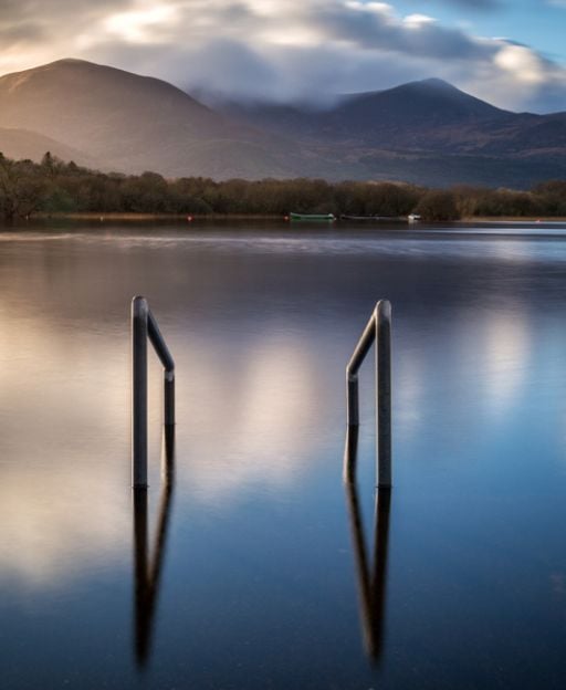 Lough Leane at dusk in Killarney, County Kerry, with the MacGillycuddy's Reeks mountains reflected in the still water