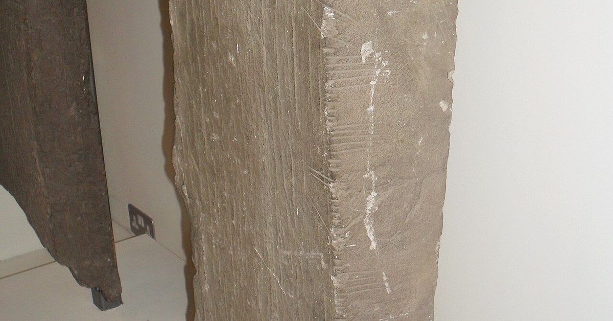 Ancient Ogham stone with carved inscriptions along the edge, Ireland