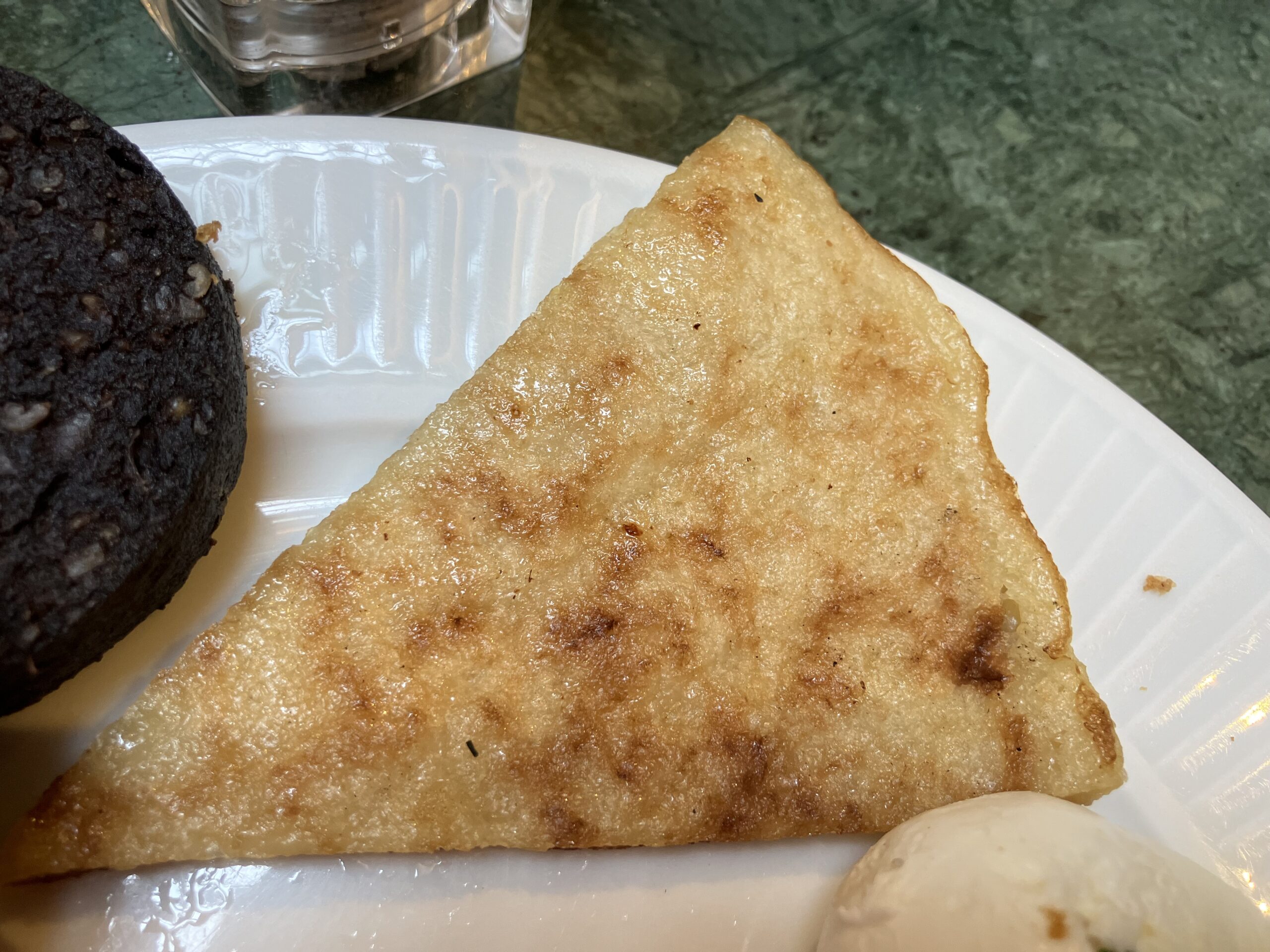 Traditional Irish boxty &mdash; a dense golden potato pancake, triangle-cut, served as part of a full Irish breakfast