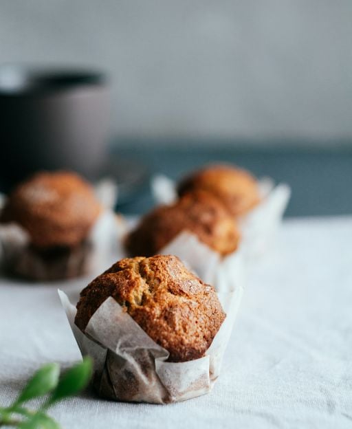 Freshly baked apple crumble muffins with golden domed tops in paper liners