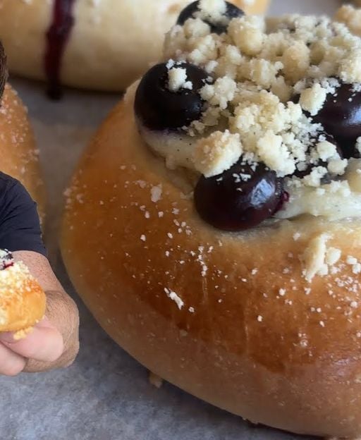 Soft blueberry cream buns with pastry cream filling and streusel topping, freshly baked on a tray
