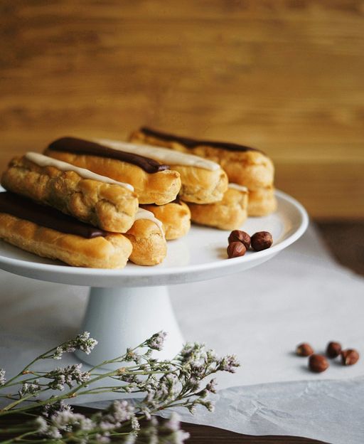 A tray of freshly baked chocolate eclairs with glossy dark chocolate glaze