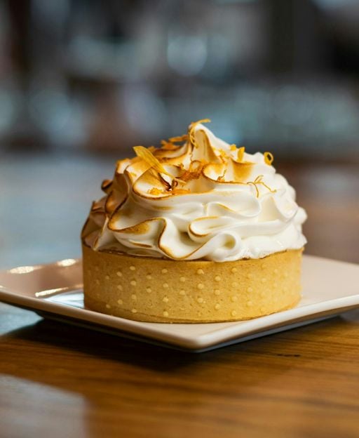 Lemon tart with buttery shortcrust pastry and creamy lemon curd filling, topped with meringue and citrus zest