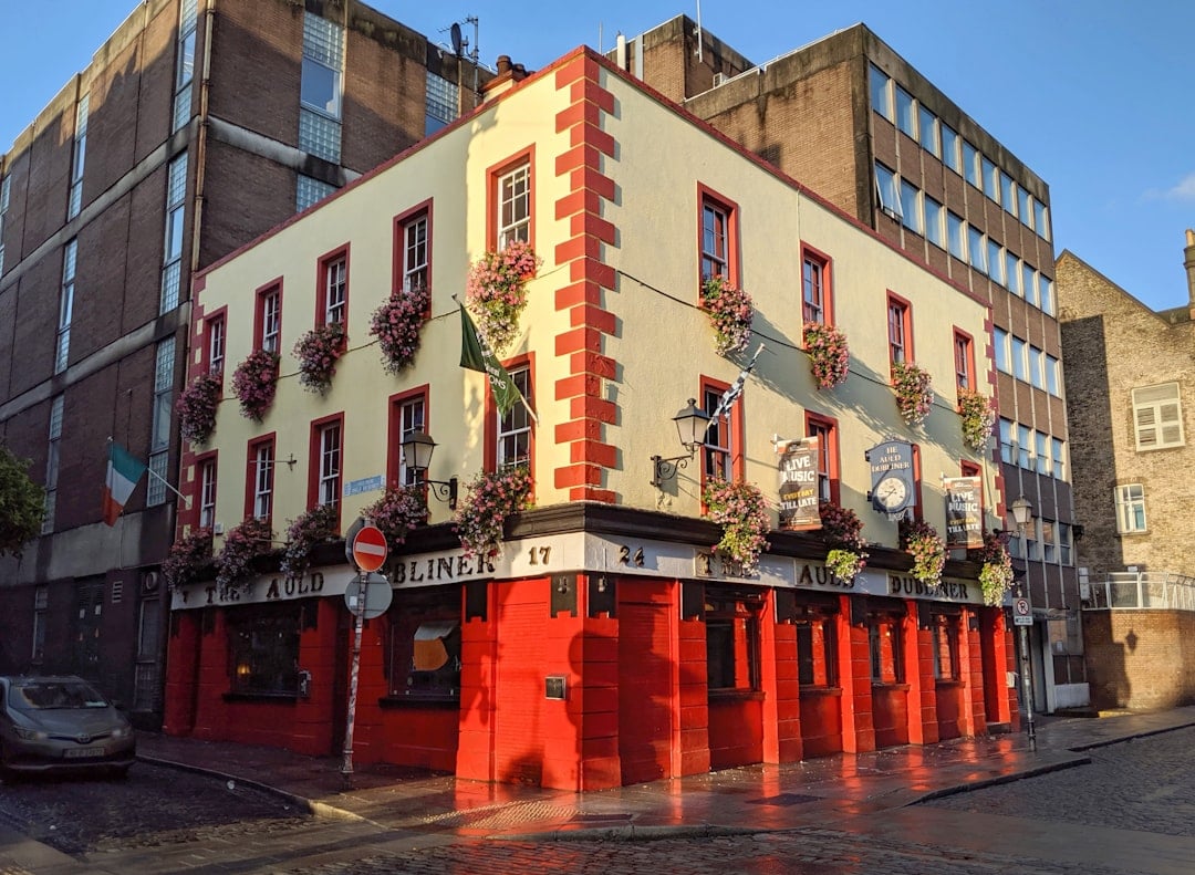 A colorful corner pub in Dublin with hanging flower baskets, historic charm and lively street atmosphere.