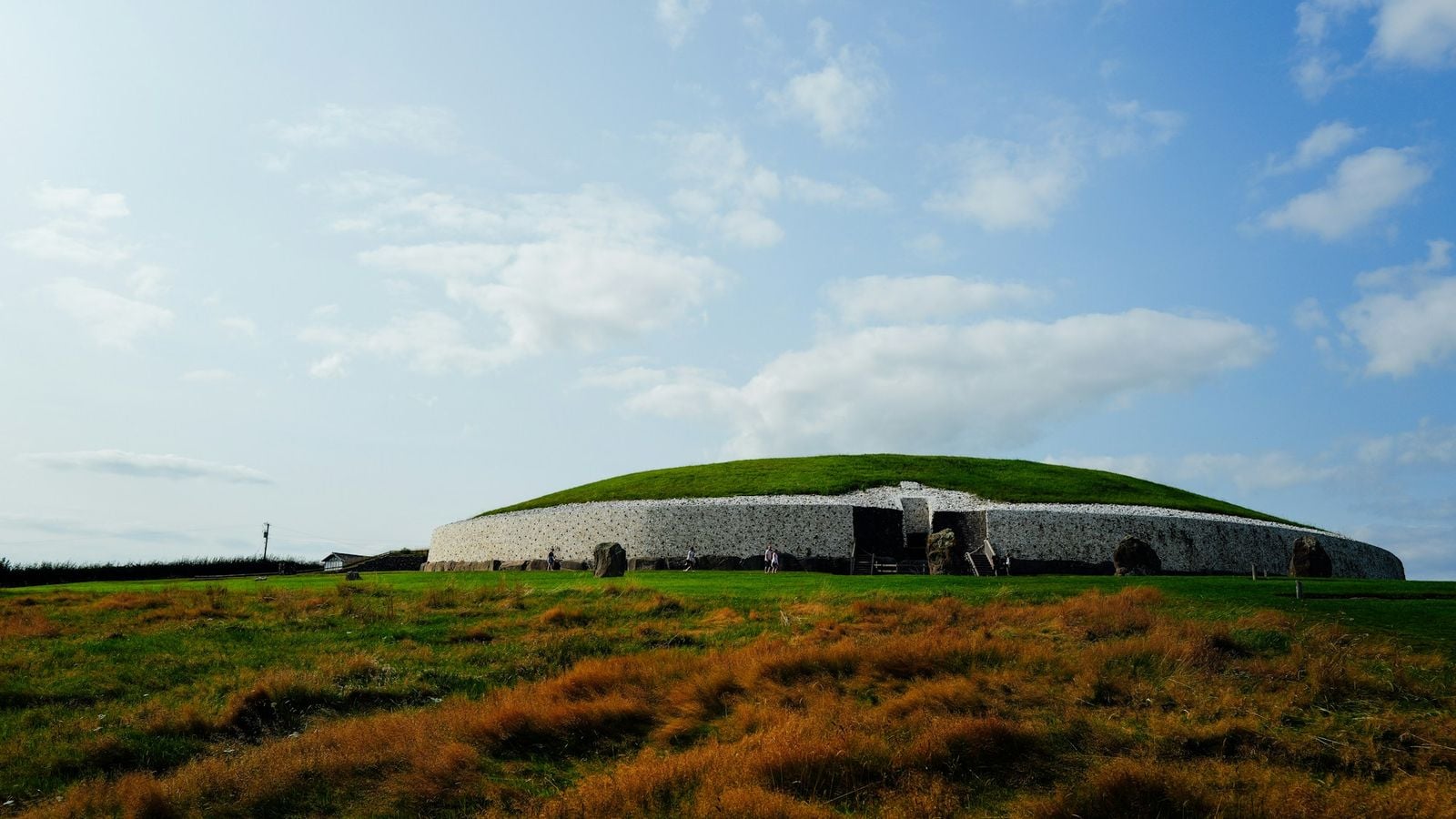 Ancient passage tomb at Newgrange in County Meath Ireland under blue sky