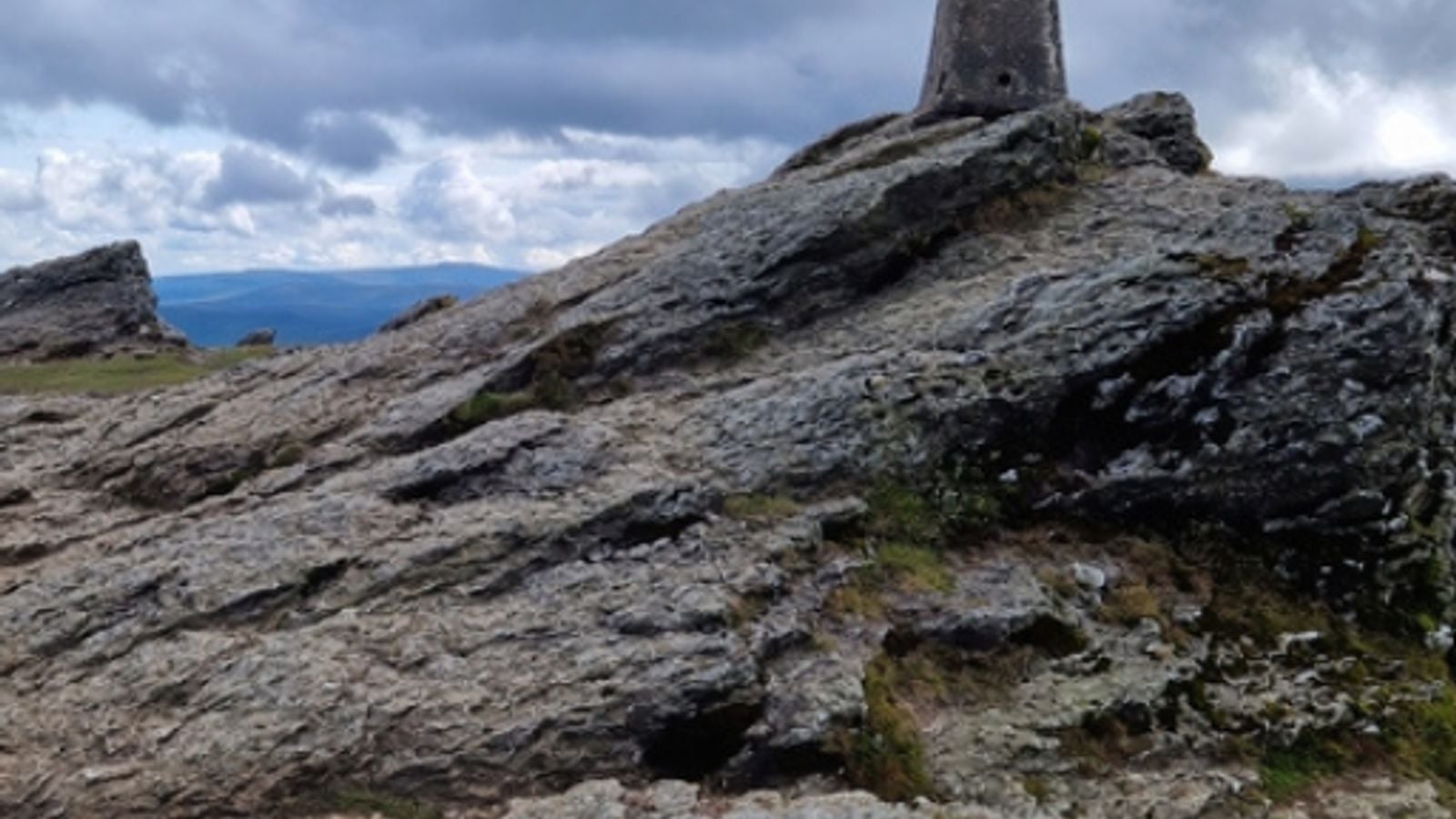Rocky peak of Djouce Mountain in the Wicklow Mountains, Ireland, on a summer day with heathered slopes stretching to the horizon