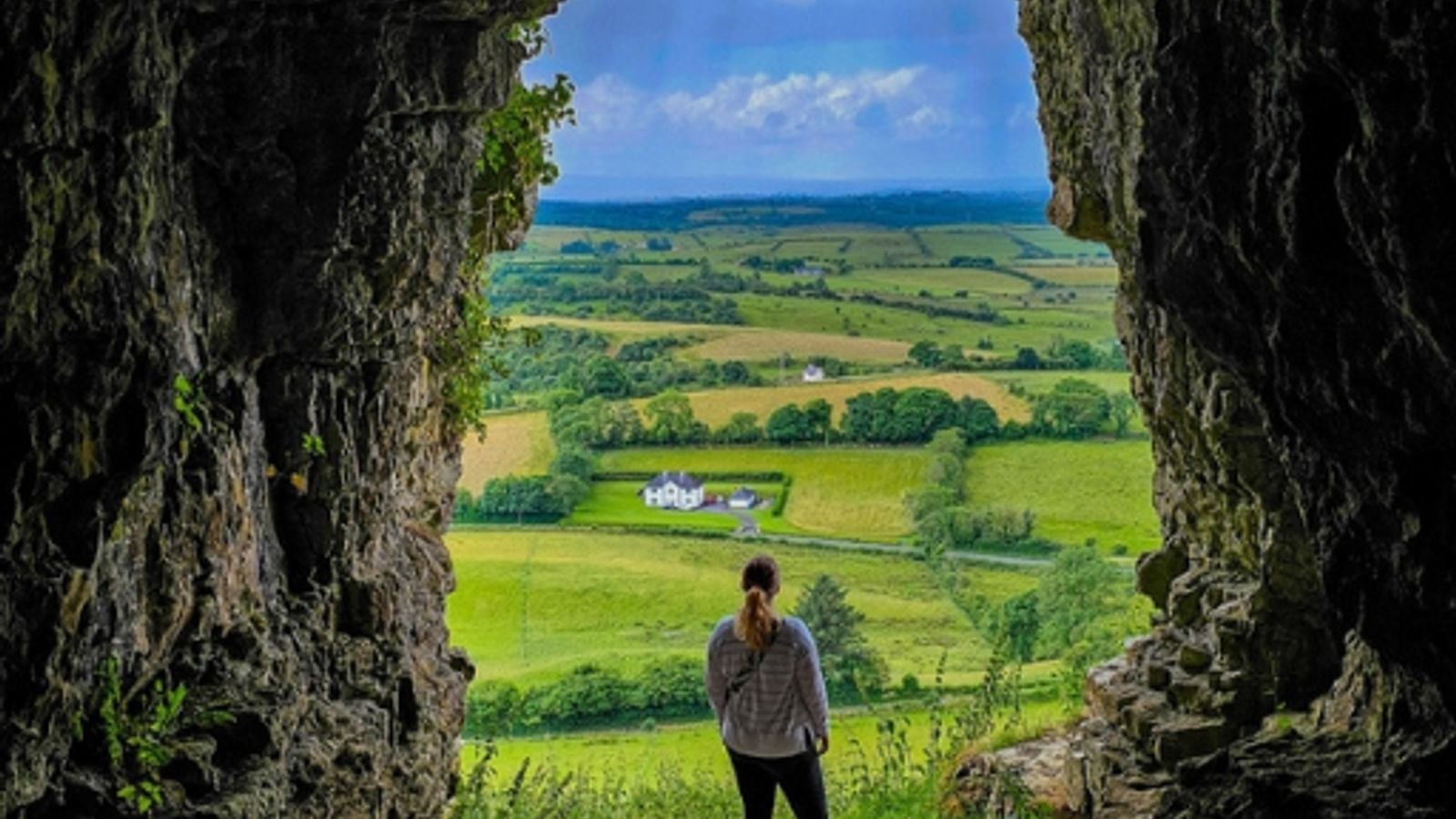 View from inside the Keshcorran caves in County Sligo, looking out over the green Irish landscape below