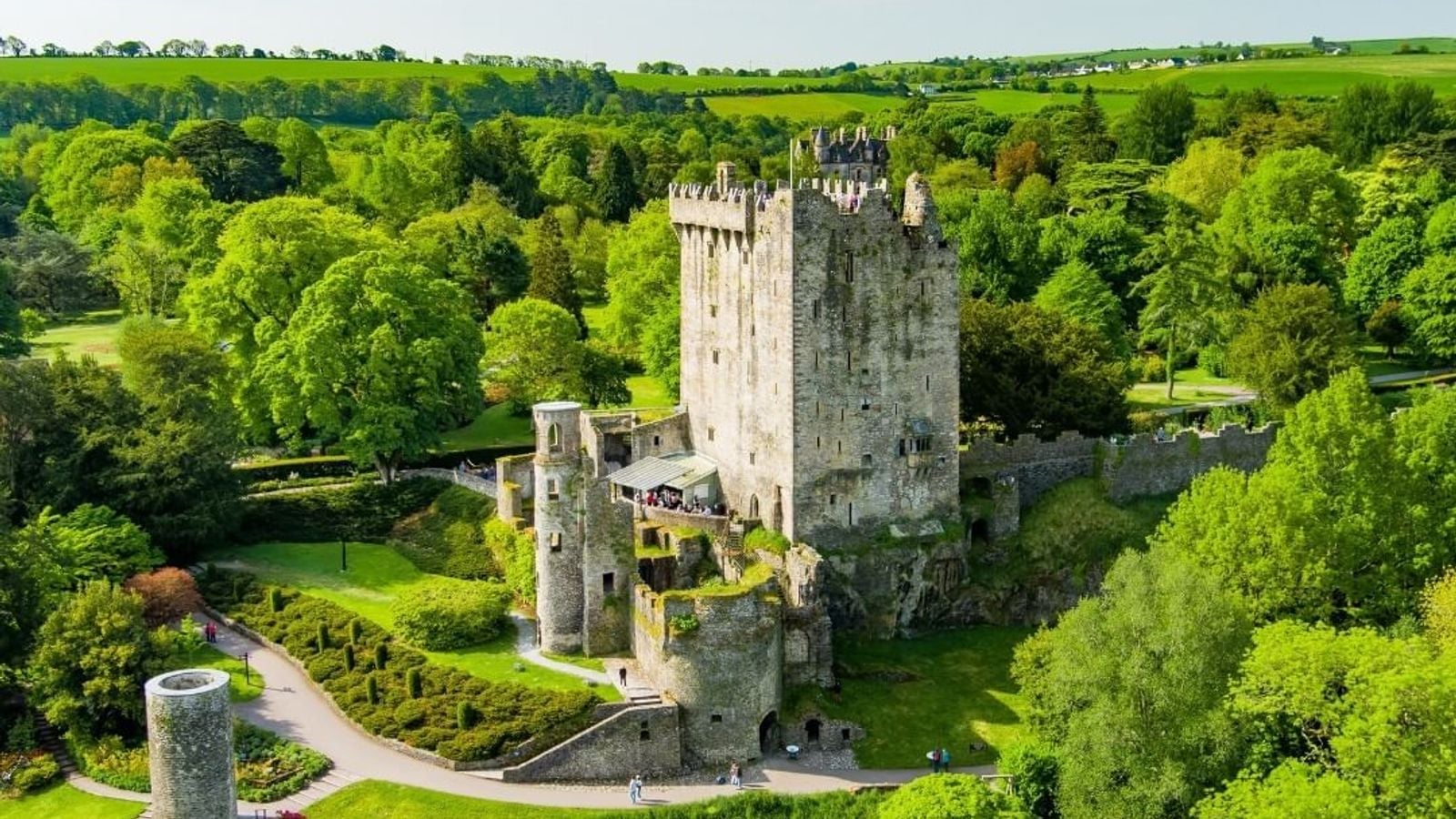 Aerial view of Blarney Castle surrounded by lush green woodlands in County Cork, Ireland