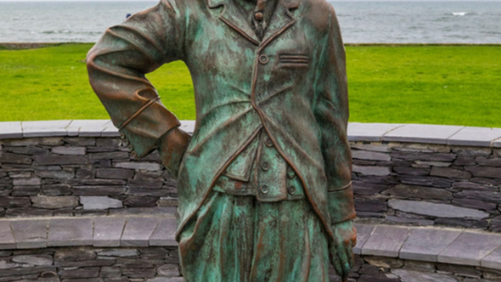 Bronze statue of Charlie Chaplin as the Tramp in Waterville, County Kerry, with the Atlantic Ocean behind him