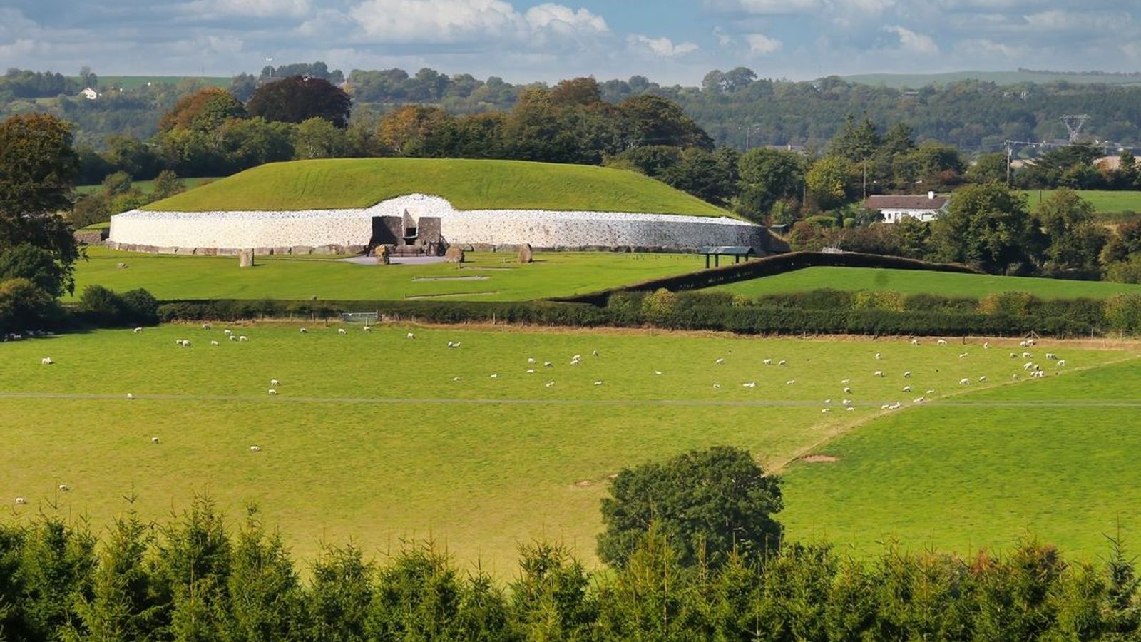 Newgrange passage tomb rising above green fields in County Meath, Ireland &mdash; home of the Tuatha D&eacute; Danann in Irish mythology
