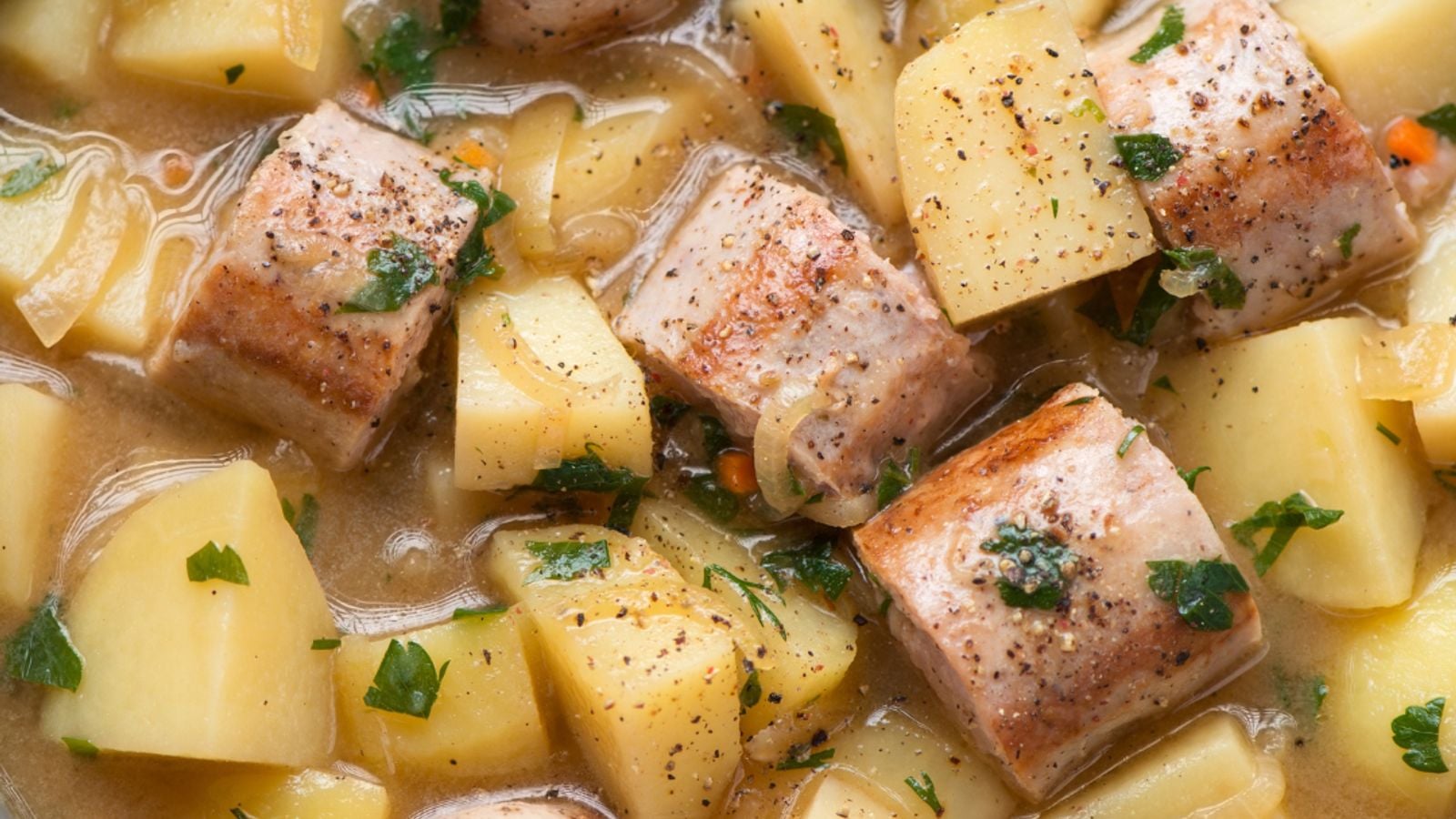 A bowl of Dublin coddle with sausages, bacon and potatoes in rich broth