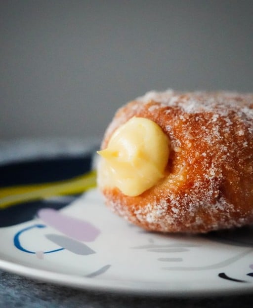 Irish cream doughnuts filled with vanilla custard, rolled in caster sugar