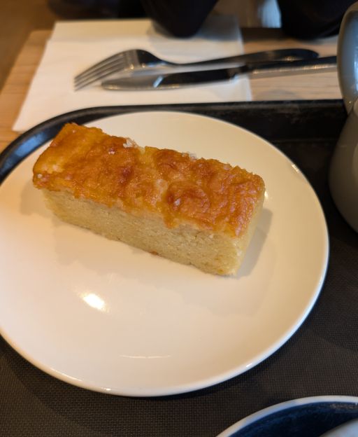 A slice of lemon drizzle cake with golden crystallised drizzle topping