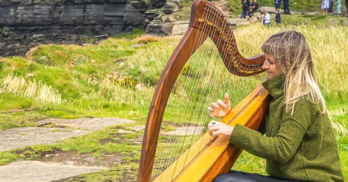 Irish harpist playing traditional Celtic harp at festival in Ireland