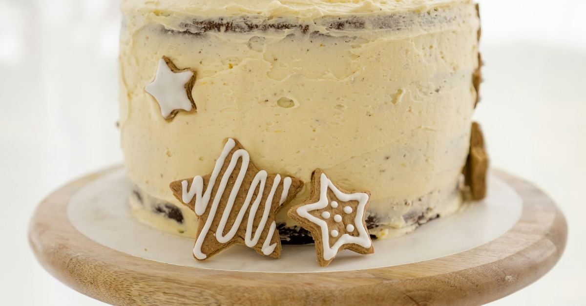 A beautifully frosted two-layer cake with ivory Swiss meringue buttercream in a rustic style