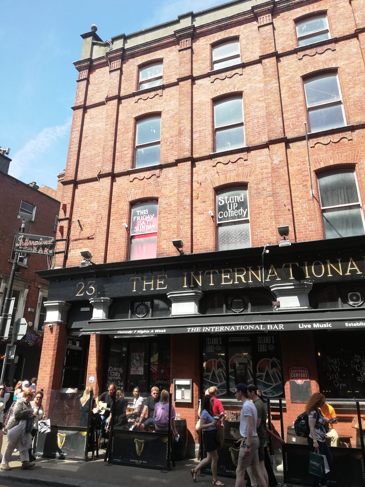 The International Bar storefront with red brick building and crowds outside