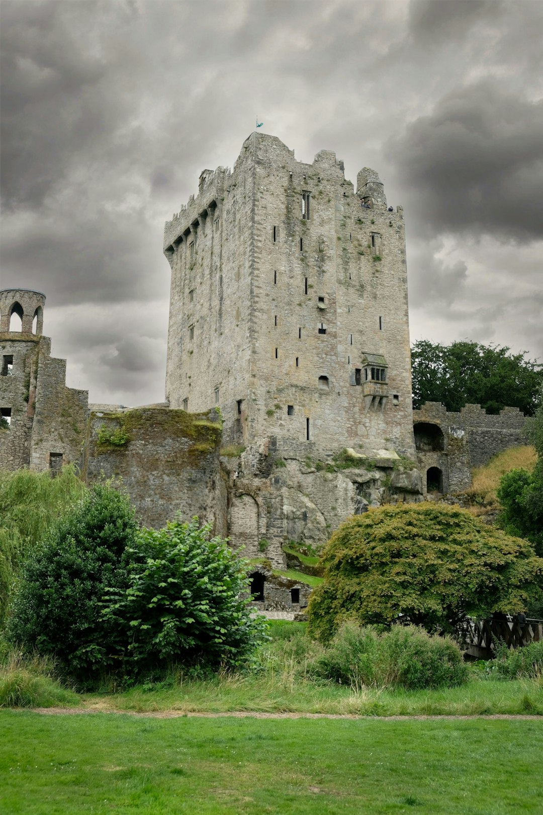 Medieval stone castle tower with ivy-covered walls under stormy sky