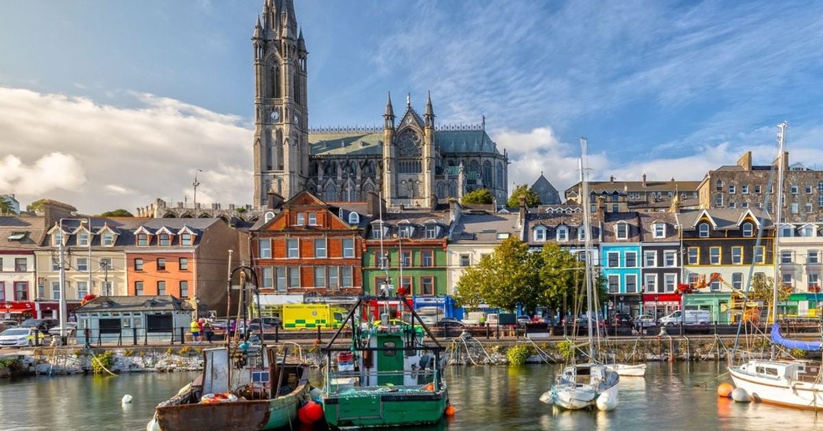 Colorful waterfront buildings and boats in Irish harbor with cathedral spire