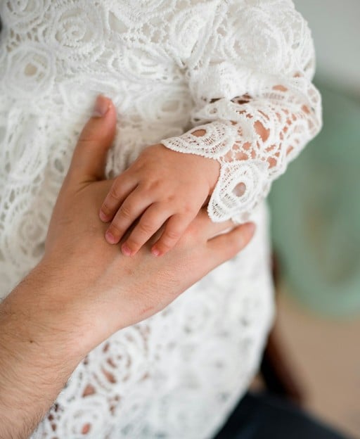 Baby hand resting on parent hand, symbolising Irish family naming traditions