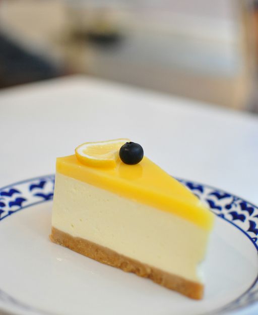 Slice of no-bake lemon cheesecake with pale yellow creamy filling and golden biscuit base