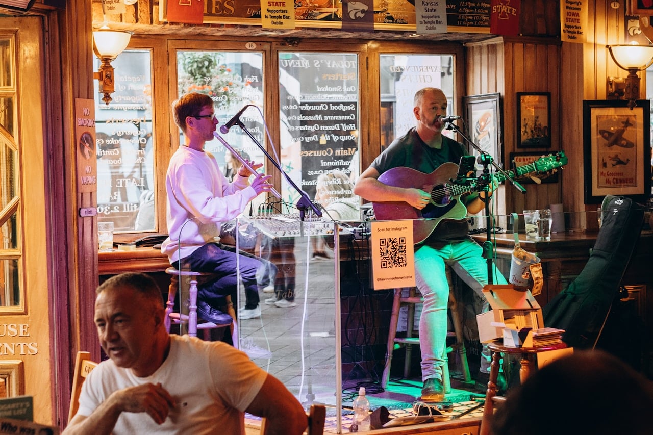 Two musicians playing guitar and wind instrument in a cosy Irish pub session