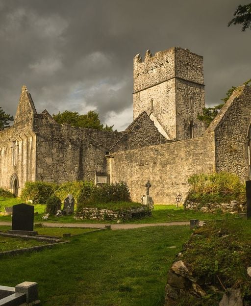 Muckross Abbey ruins, County Kerry, Ireland — ancient stone walls and graveyard