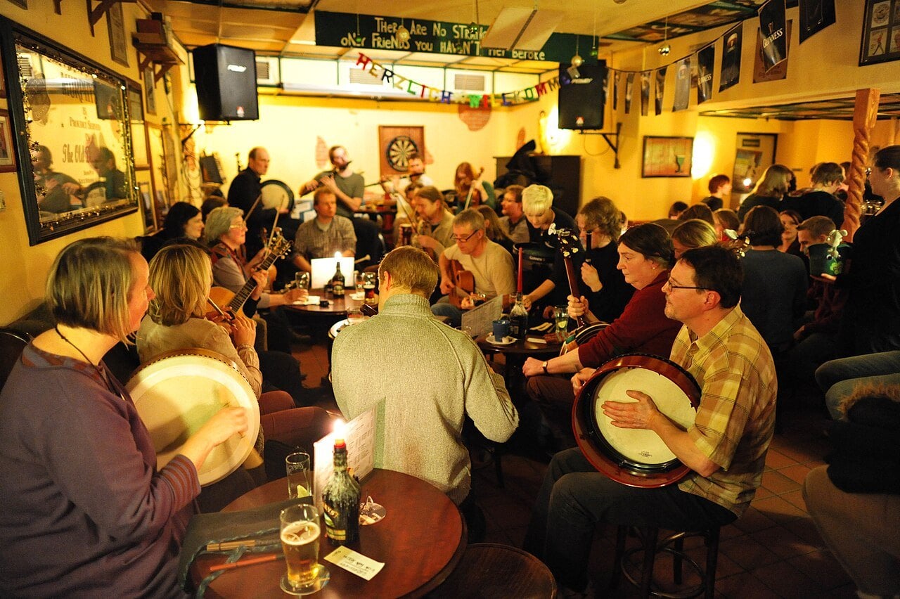 A lively traditional Irish music session in a candlelit pub &mdash; the craic in full flow