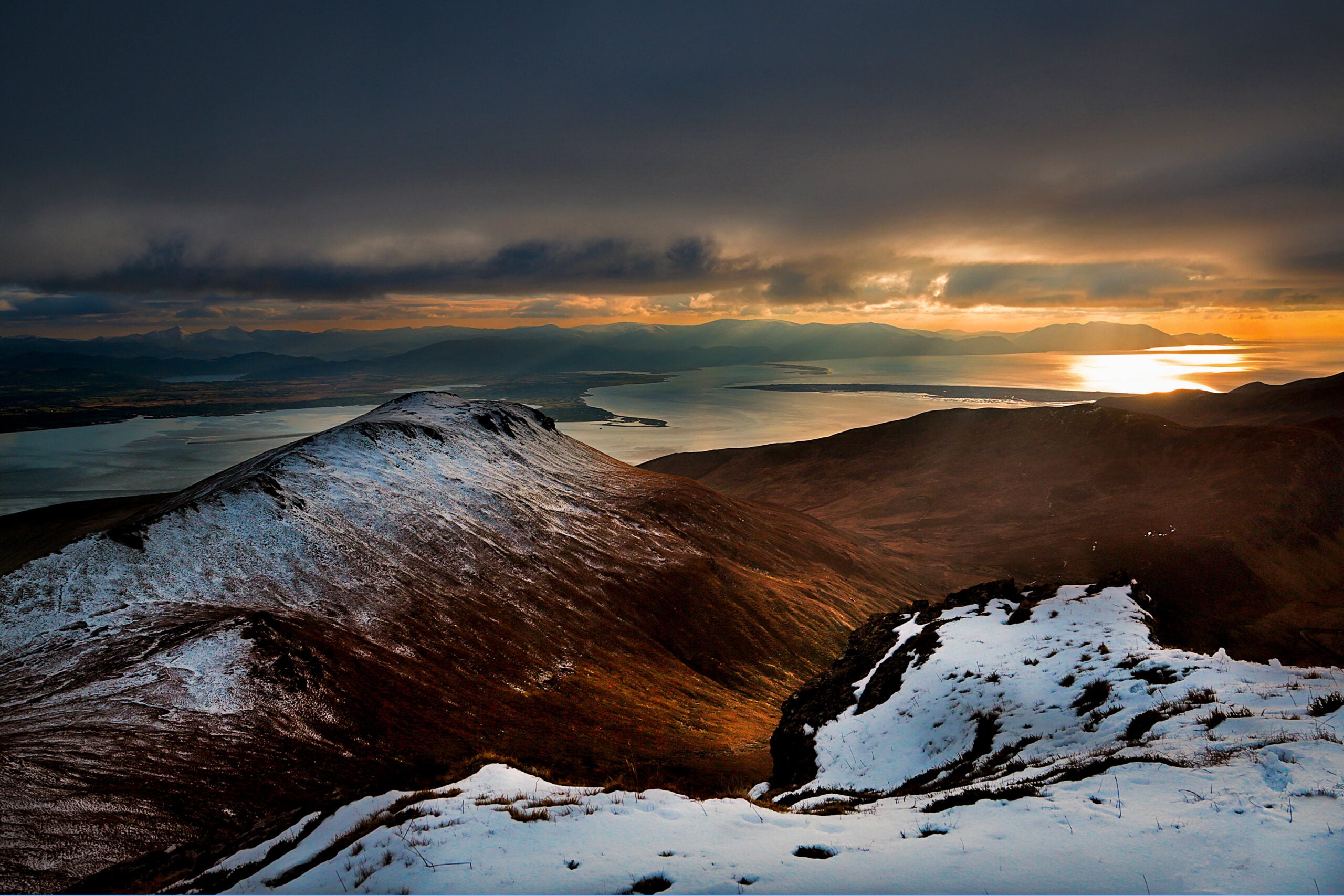 The summit of Caherconree in the Slieve Mish mountains, County Kerry, overlooking the coast at sunset &mdash; the mountain linked to the Irish myth of Bl&aacute;thnaid and C&uacute; Ro&iacute;