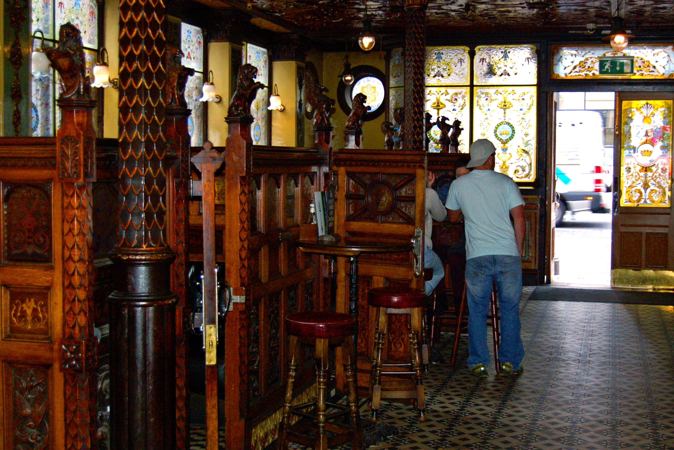 Carved wooden snug booths with etched glass panels inside Belfast's Crown Bar