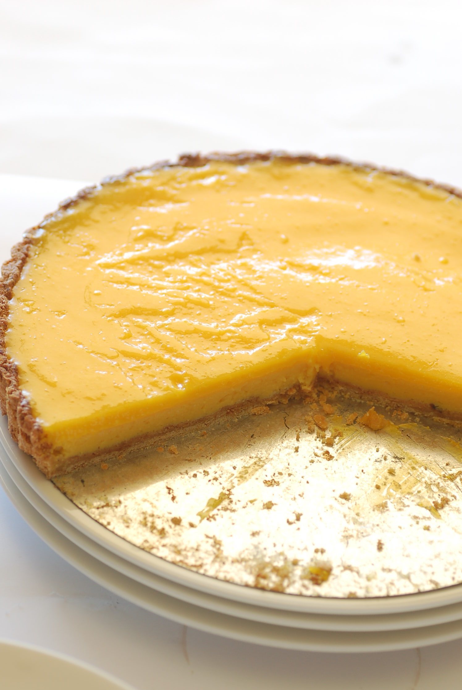 Sliced classic lemon tart showing smooth glossy lemon curd filling in a crisp shortcrust pastry shell