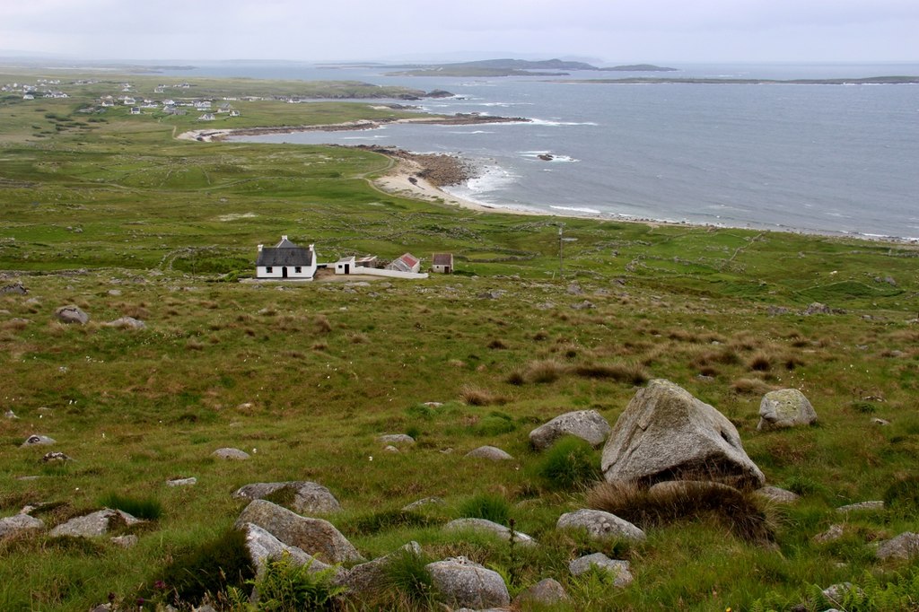 Rugged coastline of northwest Donegal with a traditional cottage overlooking the Atlantic, near where the county's glamping sites are located