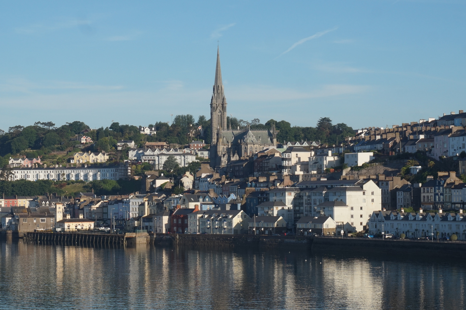 Cobh harbourfront in County Cork, Ireland, with St Colman’s Cathedral and colourful terraced houses overlooking the water — the last port of call for millions of Irish emigrants to America