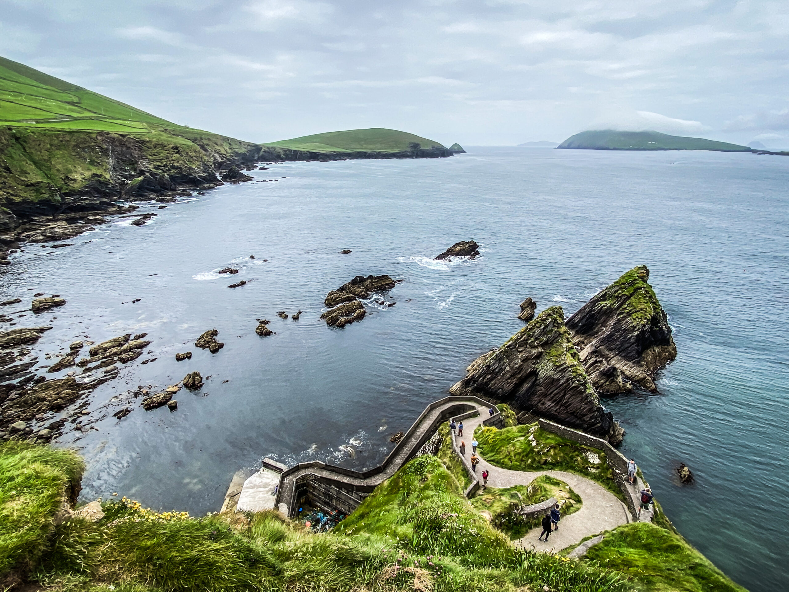 Aerial view of the zigzag steps leading down to Dunquin Pier on the Dingle Peninsula, County Kerry, Ireland, with the sea stacks and Blasket Islands beyond