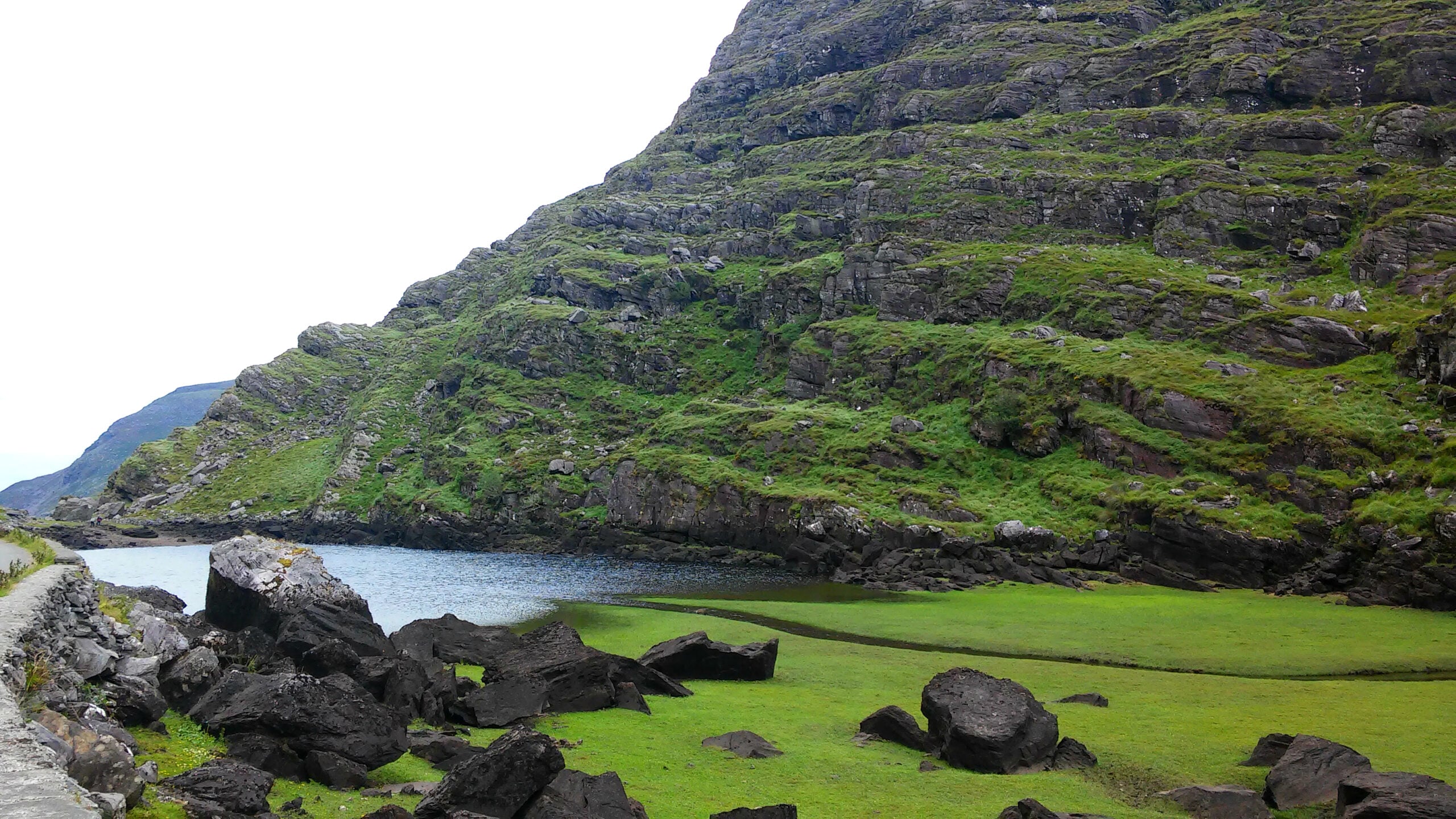 The Gap of Dunloe in County Kerry, Ireland &mdash; a glacially carved mountain pass with a lake reflecting the surrounding cliffs, road running alongside
