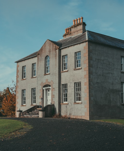 Traditional Irish stone house with gravel driveway and blue sky, representing homes in Ireland for American expats moving to Ireland