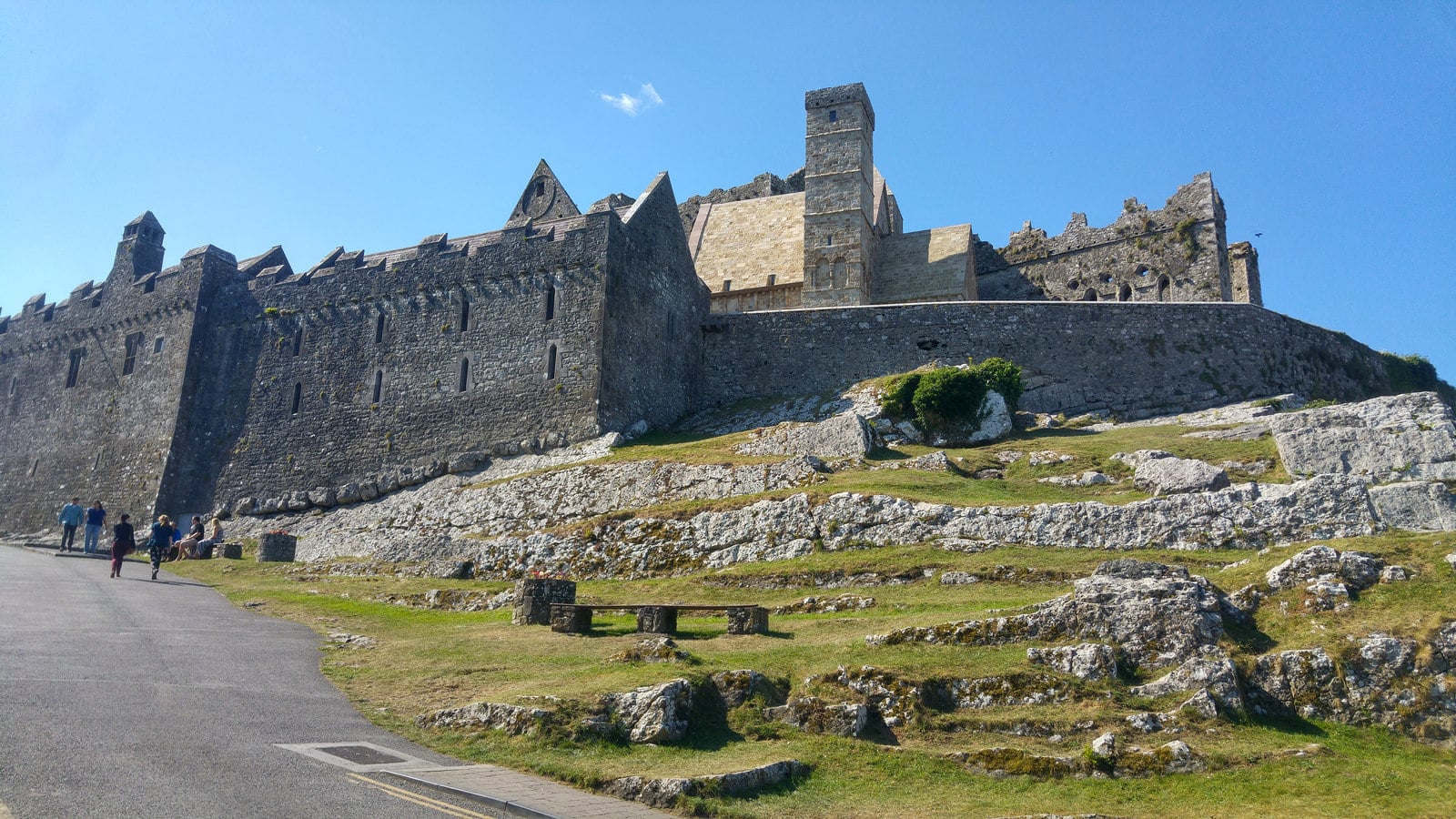 The Rock of Cashel's medieval fortress complex, including the round tower and cathedral walls, seen from the approach path in County Tipperary, Ireland